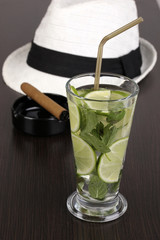 Mojito and a hat on a wooden background