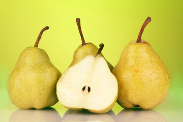 Ripe pears on bright green background