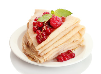 Delicious pancakes with berries and jam on plate on wooden