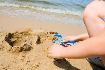 little girl hand playing on the beach