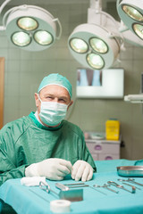 Surgeon sitting in front of surgical tools