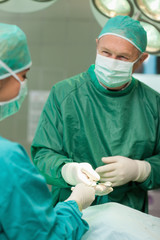 Smiling surgeons holding scissors