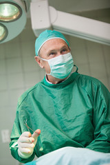 Smiling surgeon holding scissors