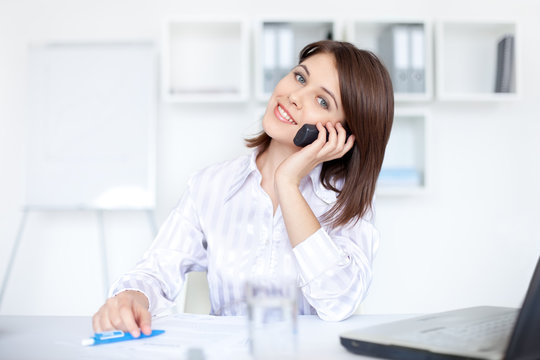beautiful young business woman speaking on phone call at office
