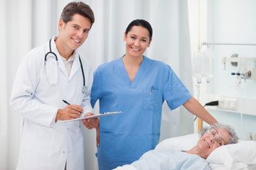 Doctor smiling while holding a clipboard