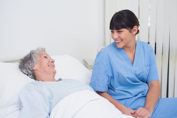 Fototapeta premium Nurse smiling to an elderly patient