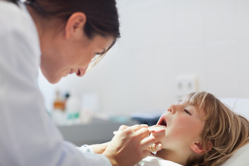 Obraz na płótnie Canvas Doctor auscultating the mouth of a child