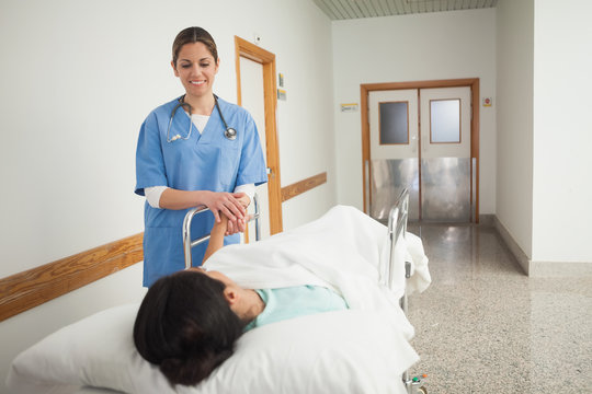 Female patient holding the hand of a nurse
