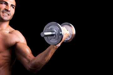 Healthy young man lifting weights on black background