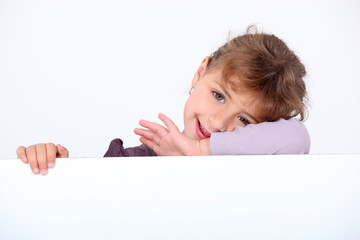 Little girl posing with blank advertisement board