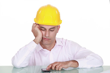 An architect sadly looking at his phone.