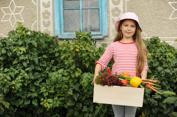 Girl with a box of vegetables