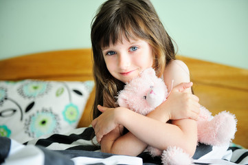 Portrait of awaken little girl sitting in bed © Alinute