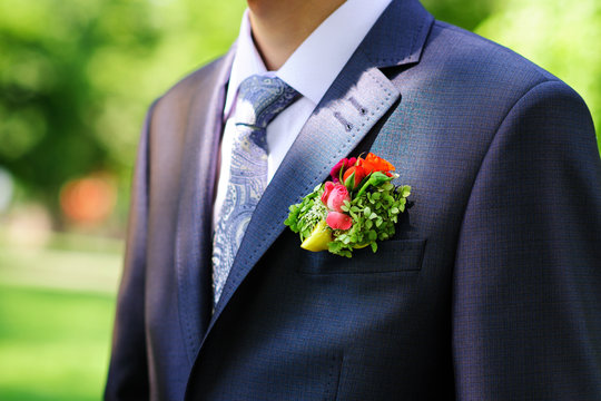 Groom in black suit wearing buttonhole
