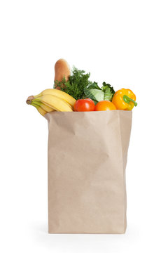 Paper bag with healthy food over white background