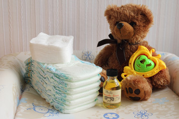 Couches de bébé  avec huile d’amande douce et un ours en peluche. Toilette de bébé © Aygul Bulté