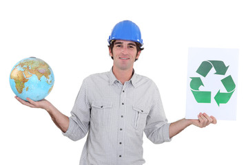 Construction worker holding a globe and recycle sign