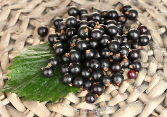 Fresh black currant on wicker mat close-up