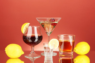 a variety of alcoholic drinks on red background