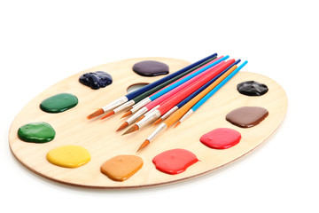 wooden art palette with  paint and brushes.isolated on white