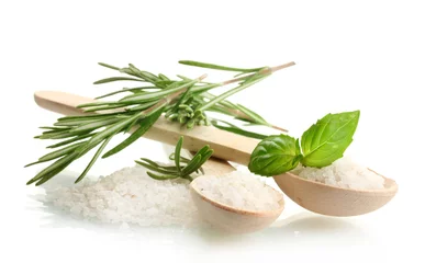 Keuken foto achterwand Specerijen zout in lepels met verse basilicum en rozemarijn geïsoleerd op wit