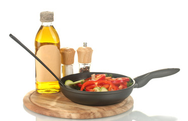 frying pan with vegetables on white