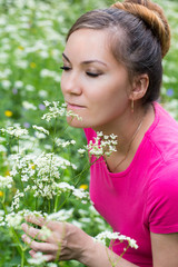 Obraz premium Portrait of beautiful young woman with flowers on nature