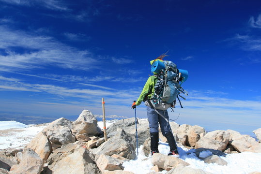 Woman with backpack on top of mountain