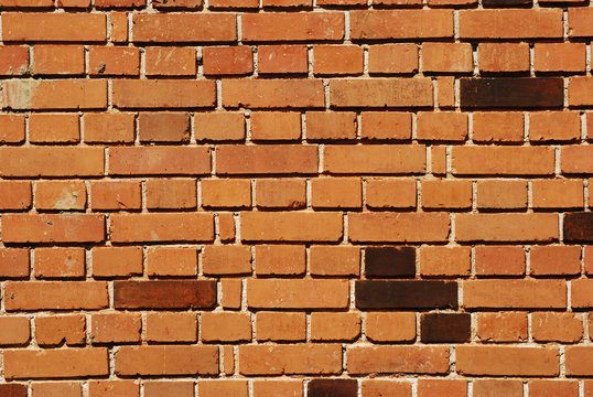 Red bricks non-plastered house wall as background