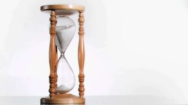 White sand in super slow motion falling from a hourglass