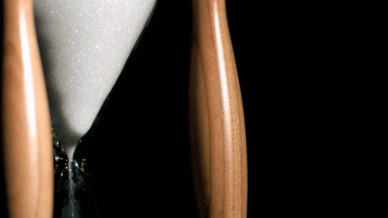 Sand in super slow motion dropping from an egg timer