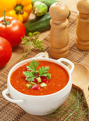 Gazpacho and ingredients on a table, vegetable soup