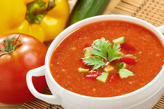 Gazpacho and ingredients on a table, vegetable soup