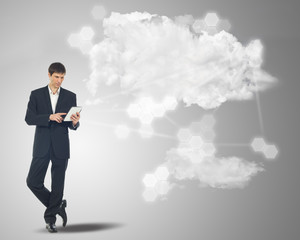 Businessman with touch screen Internet Tablet and the clouds
