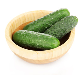 Fresh cucumbers in wooden bowl isolated on white
