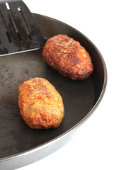 Tasty burgers in the pan on white background close-up