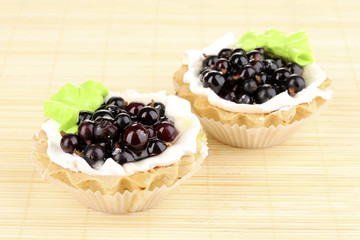 sweet cakes with berries on bamboo mat