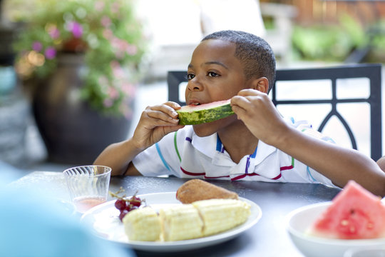 African American boy eating watermelon - Powered by Adobe