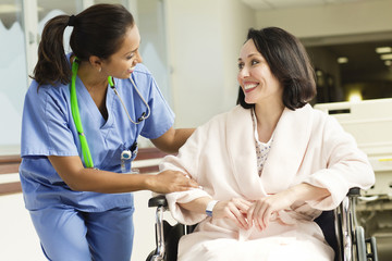 Nurse talking to patient in wheelchair in hospital