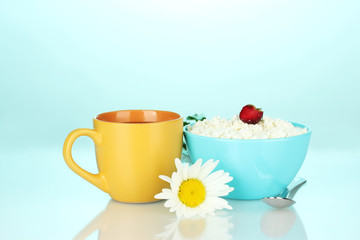 cottage cheese with strawberry in blue bowl and orange cup with