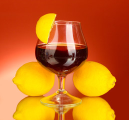 glass of brandy on red background close-up