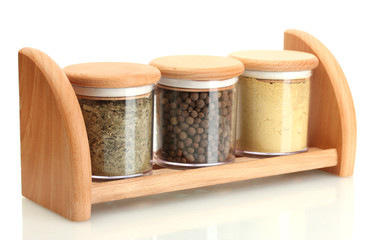 jars with spices on wooden shelf isolated on white
