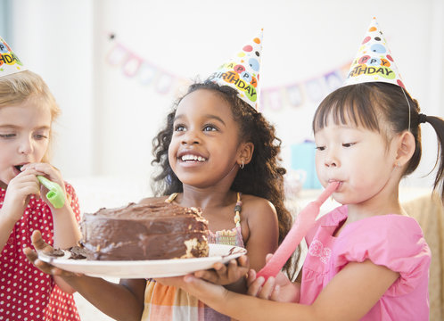 Girls holding birthday cake together
