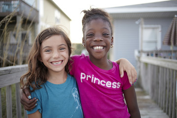 Grinning girls hugging outdoors