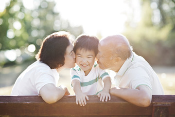 Chinese grandparents kissing grandson