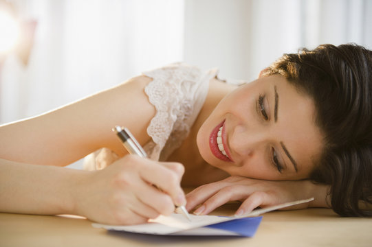 Mixed Race Woman Writing On Birthday Card