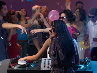 woman dj entertaining crowd in night club