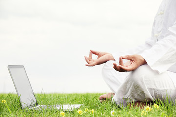 Man sitting in meditative lotus position with notebook