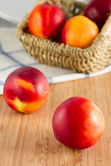 Sweet nectarines in basket on wood table