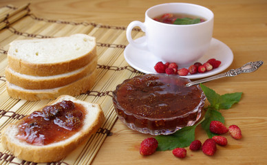 Tea with ripe strawberries and jam